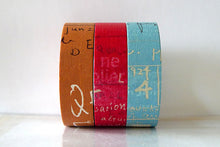 three rolls of graffiti dark set colors, brown, red, blue